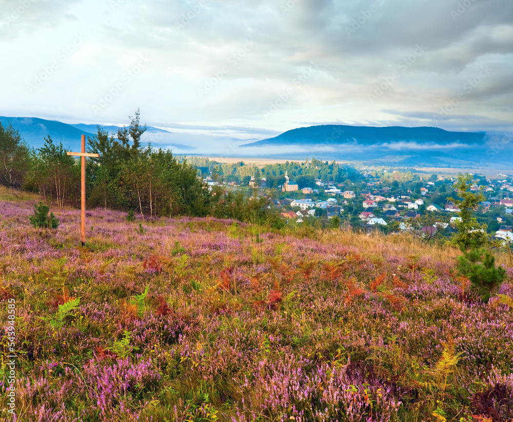 Summer heather flower hill and misty morning country view behind