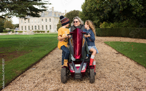 disabled grandma on a mobility scooter with her grandchildren outdoors
