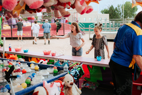 Two young girls playing a carnival game