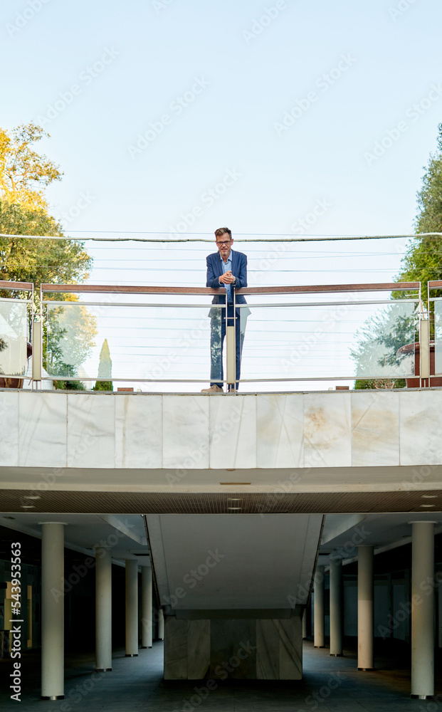 caucasian businessman standing in front of a corporate building caucasian businessman standing in front of a corporate building