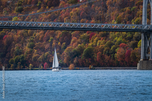An Autumn view of the mid-Hudson bridge in New York state with a sail boat in the river