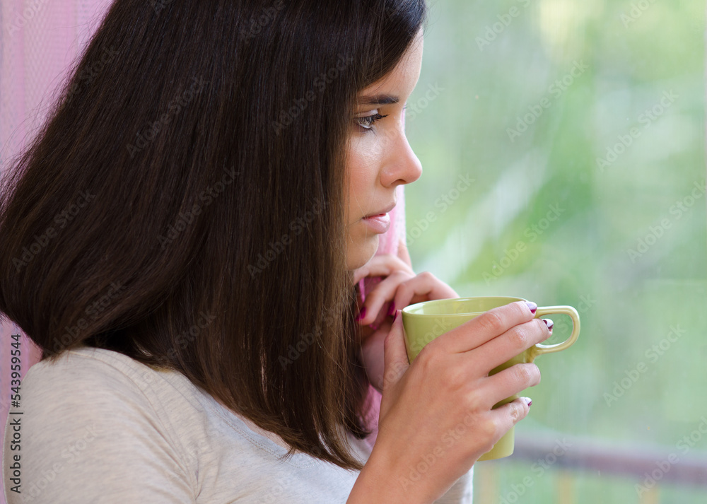 Φωτογραφία Portrait of beautiful young woman drinking coffee beside windows on sunny summer