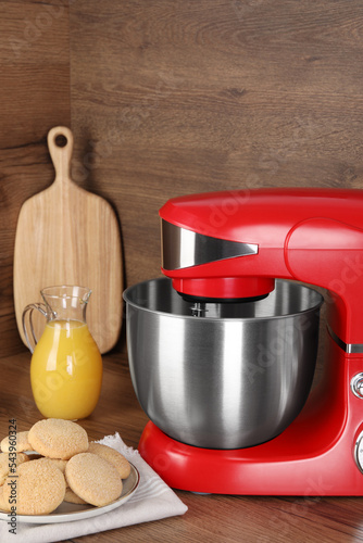 Composition with modern red stand mixer and different products on wooden table