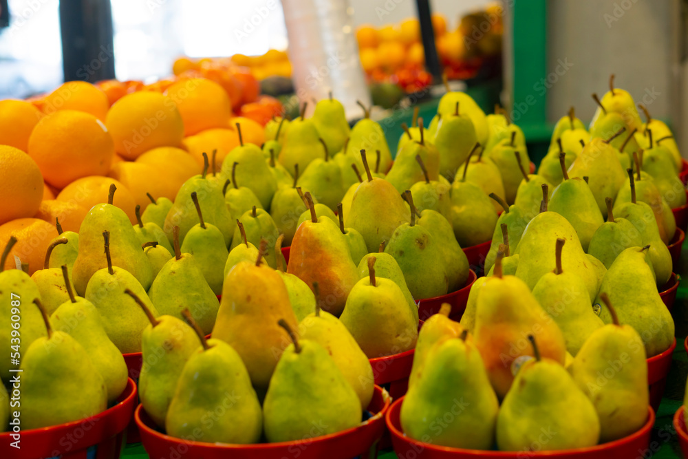 Delicious ripe pear in the store on the counter. Fresh pears in male hands. Juicy flavorful pears in box, basket. Organic fruit for food or pear juice. Healthy food. Pear harvest.