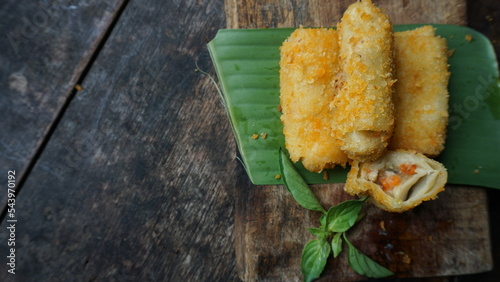 Selective focus risoles sosis mayo or mayonnaise sausage rissole is a small patty rolled in breadcrumbs. it is filled with mayonnaise, boiled egg and sausage. Served on wooden table. photo