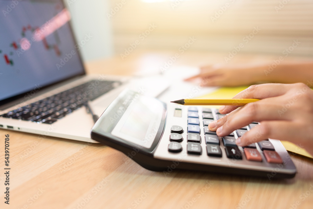Bank employee checking account on his calculator Bank employee checking account on his calculator
