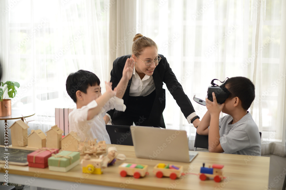 Teacher teaching her young students drawing toys or wood model on the laptop. Teacher teaching her young students drawing toys or wood model on the laptop.