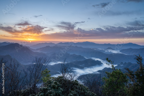 landscape with sunrise and cloud sea over mountains in froggy morning © imphilip