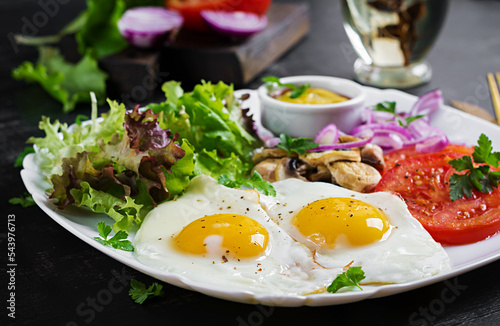 Ketogenic food. Fried eggs, mushrooms and sliced tomatoes. Keto, paleo breakfast.