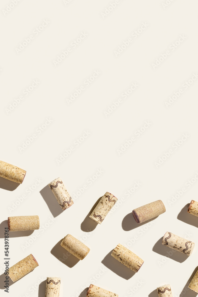 Creative pattern with wine corks on beige background with hard light and shadows at sunlight. Minimal style layout with bottle stoppers from red white wine, top view, wine list backdrop