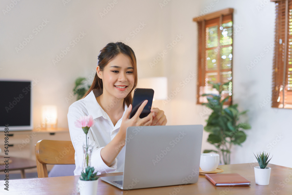 Working at home concept, Women using smartphone and laptop to working at modern home office Working at home concept, Women using smartphone and laptop to working at modern home office