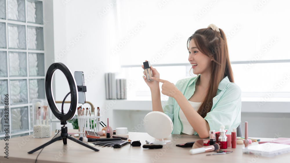 Beauty Vlogger concept, Young woman point on liquid foundation bottle to introduce product on Vlog Beauty Vlogger concept, Young woman point on liquid foundation bottle to introduce product on Vlog