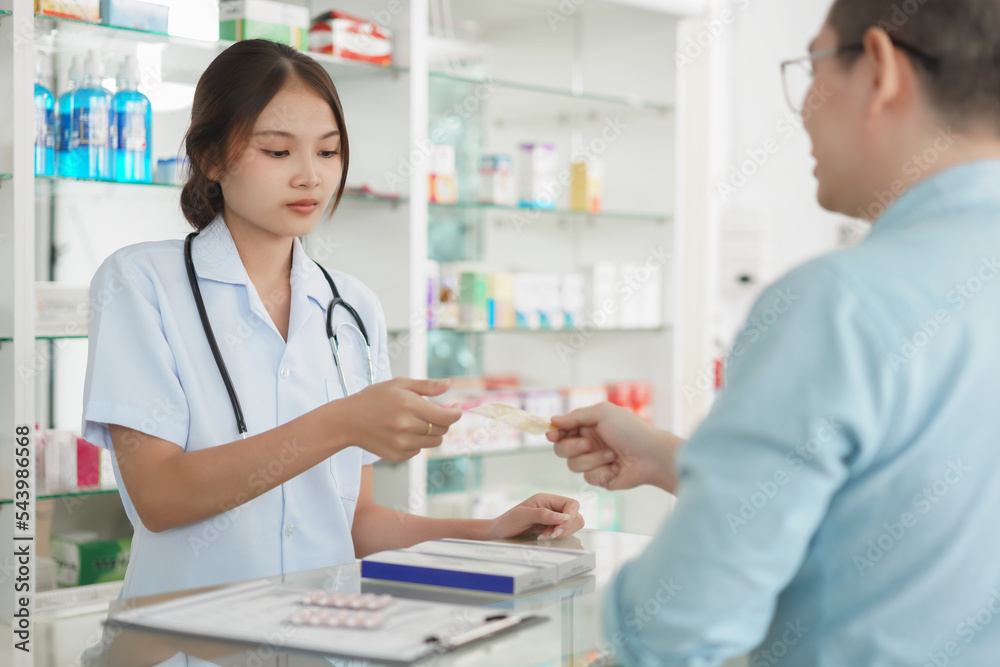 Medicine and health concept, Male client use credit card to buying medicines from female pharmacist