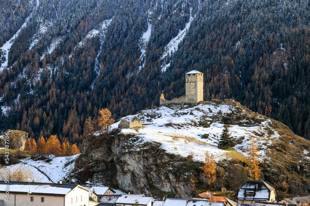 Ruins Steinsberg from the ancient Medieval Castle Steinsberg over the Swiss Alp village Ardez with snow mountain at the background in Engadin valley, Graubunden Canton