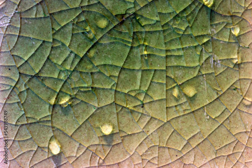 Close up to background and texture of stretch marks cracked on emerald green glazed tile. Scratches background. Vintage scratched grunge tile broken screen texture. Scratched glass surface wallpaper.