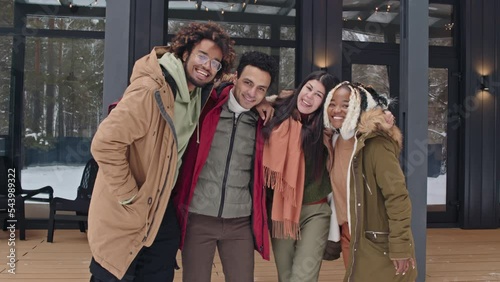 Wallpaper Mural Medium long slow motion shot of four multi-ethnic friends standing against country house on winter day posing on camera hugging each others Torontodigital.ca