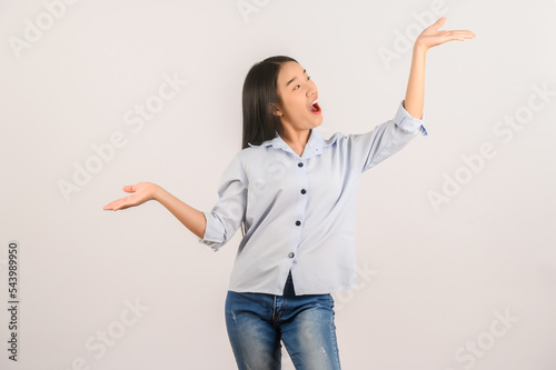 Portrait of young asian woman pointing with two hands and fingers to the side over isolated white background