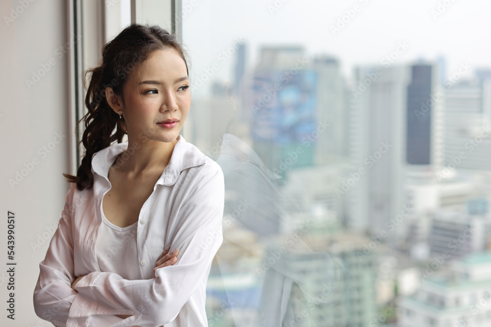 Portrait of confident and beautiful young asian businesswoman with happy smiling face standing and looking away in modern hotel with city blurred background. Success business and lifestyle concept Portrait of confident and beautiful young asian businesswoman with happy smiling face standing and looking away in modern hotel with city blurred background. Success business and lifestyle concept