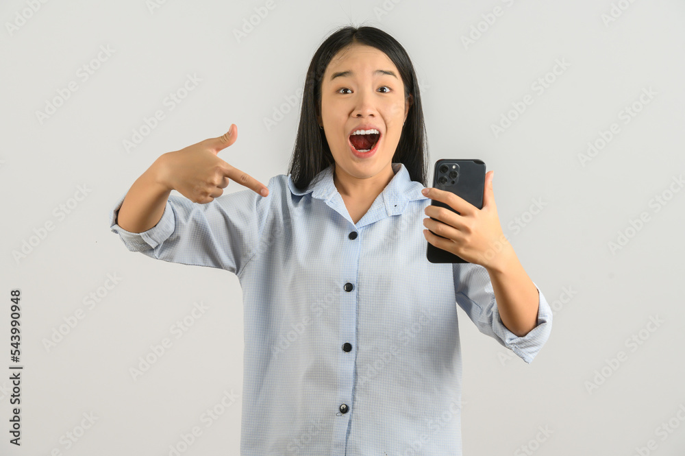 Portrait of Young asian woman expressing surprise while using mobile phone isolated over white background Portrait of Young asian woman expressing surprise while using mobile phone isolated over white background