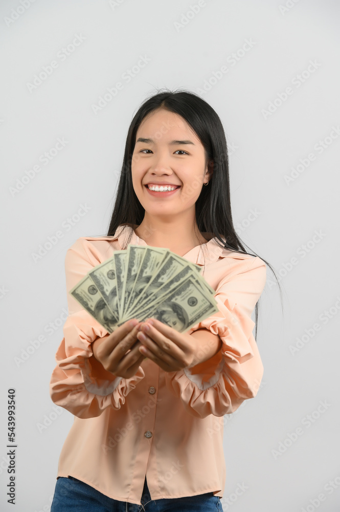 Portrait of a cheerful young woman holding money banknotes and celebrating isolated over white background Portrait of a cheerful young woman holding money banknotes and celebrating isolated over white background