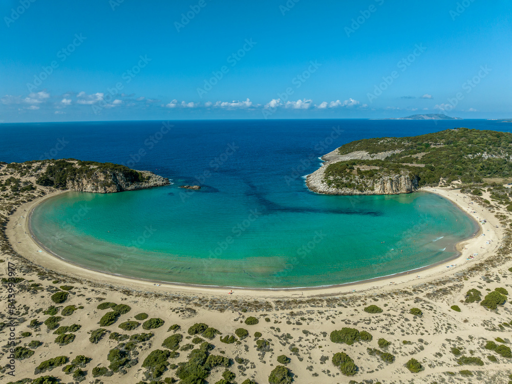 Aerial view of Voidokilia beach on the Navarino coast in Greece with turquoise water forming a crescent half moon bay popular vacation spot for German tourists