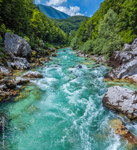 Soca Valley  Slovenia - Aerial panoramic view of the emerald alpine river Soca with rafting boats going down the river on a bright sunny summer day with green foliage. Whitewater rafting in Slovenia