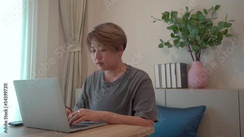 Asian lesbian couple laugphing together while in cosy bedroom, LGBTQ in happy moment using computer technology laptop shopping online, connect to social community network, lesbian lifestle concept
 photo