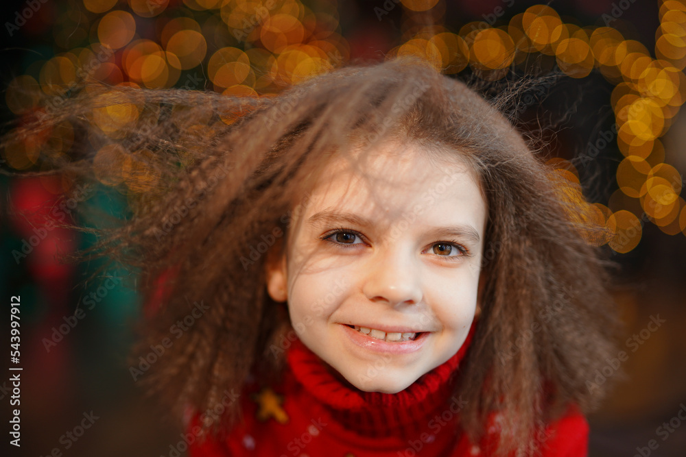 Closeup portrait of cute beautiful girl wears in christmas sweater in decorated living room background Closeup portrait of cute beautiful girl wears in christmas sweater in decorated living room background