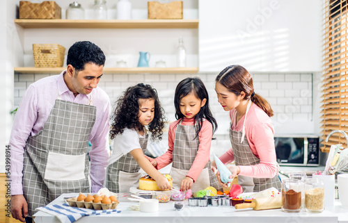 Portrait of enjoy happy love asian family father and mother with little asian girl daughter child play and having fun cooking food together with baking cookie and cake ingredient in kitchen