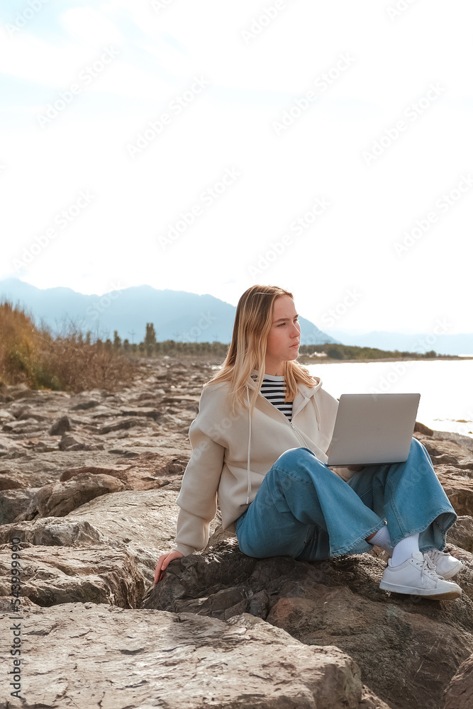 Remote work.Girl freelancer works remotely on the sea shore. workation, remote work,WFVH,Van Life vibes work from vacation home,work travel,remotely work.Travelling.Work from vacation remotely