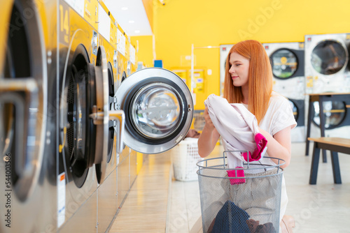 European woman washing her clothes by a washing machine