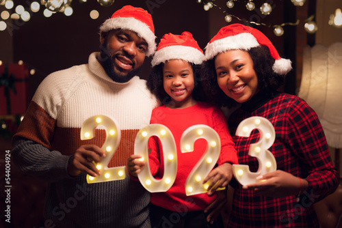 American family in 2023 new year party and merry christmas with 2023 text number photo