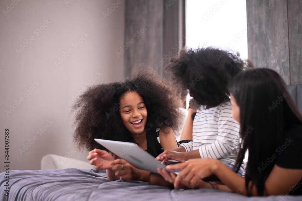 Happy time of family watching movie online on laptop in bedroom at home together Happy time of family watching movie online on laptop in bedroom at home together