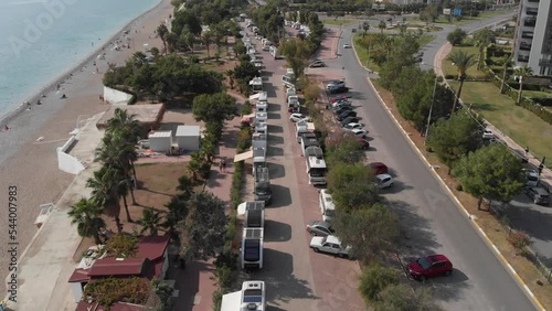 A camping place on the coast. A bird's-eye view from the unmanned aerial vehicle of the caravan motorhome camping. Surrounded by nature on the shores of the Mediterranean Sea. 4k  photo