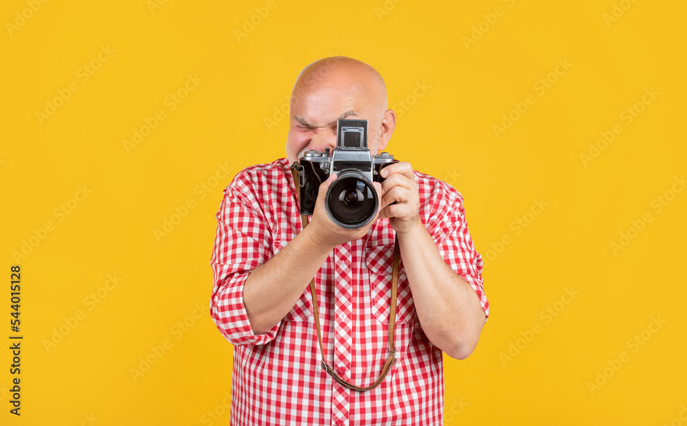 aged man with retro photo camera on yellow baqckground aged man with retro photo camera on yellow baqckground