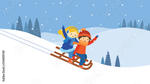 Boy and girl sledding down the hill