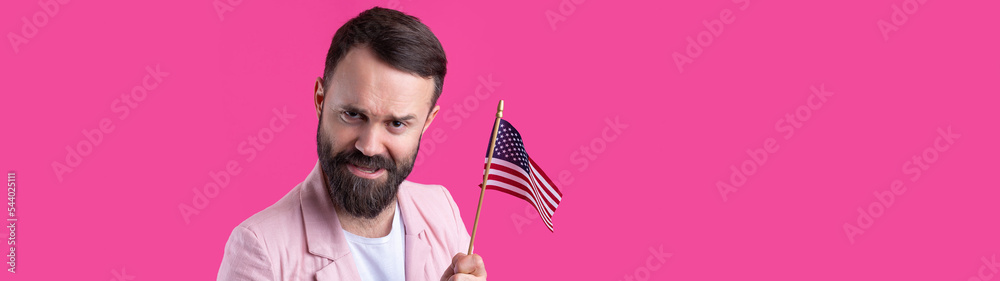 Portrait of a satisfied young man with a beard with an American flag on a red studio background. Great US patriot and defender of freedom. Portrait of a satisfied young man with a beard with an American flag on a red studio background. Great US patriot and defender of freedom.