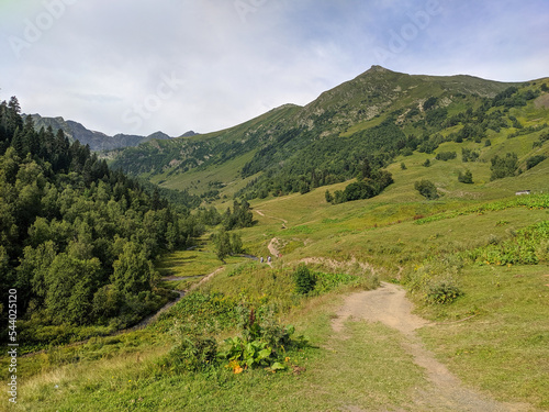 Beautiful view of the landscape of the Caucasus mountains. People are walking along the path in a group. Arkhyz, Karachay-Cherkessia, Russia