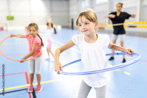 Girl practicing hula hoop at school sports court photo