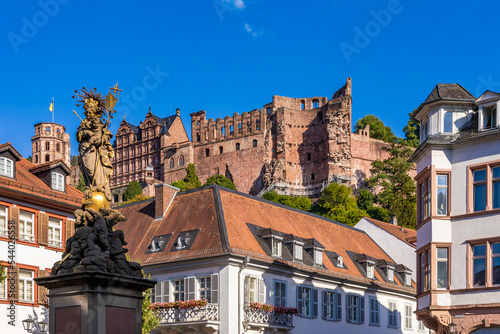 Germany, Baden-Wurttemberg, Heidelberg, Statue of Virgin Mary on Kornmarkt square with Heidelberg Castle in background photo