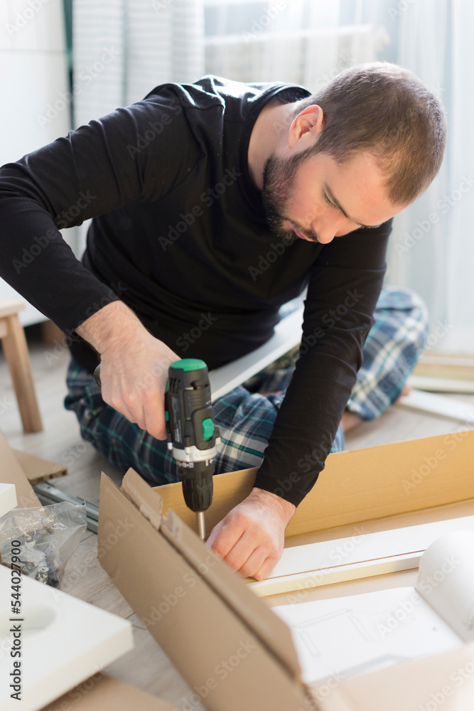 Man using drill machine on table at home Man using drill machine on table at home