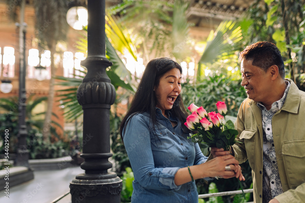 Smiling man giving flowers to woman on Valentine's Day
