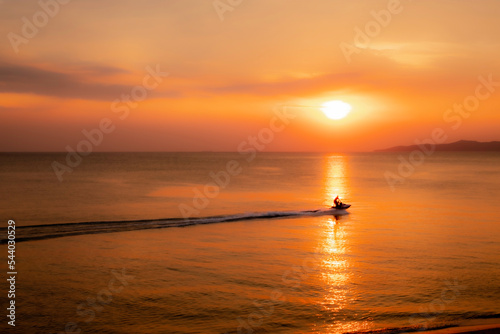 Silhouette of tourists riding a jet ski in the sea