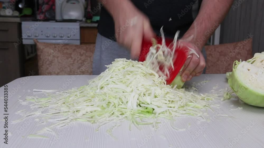 A man is chopping cabbage. Sauerkraut in a jar. Harvesting vegetables
