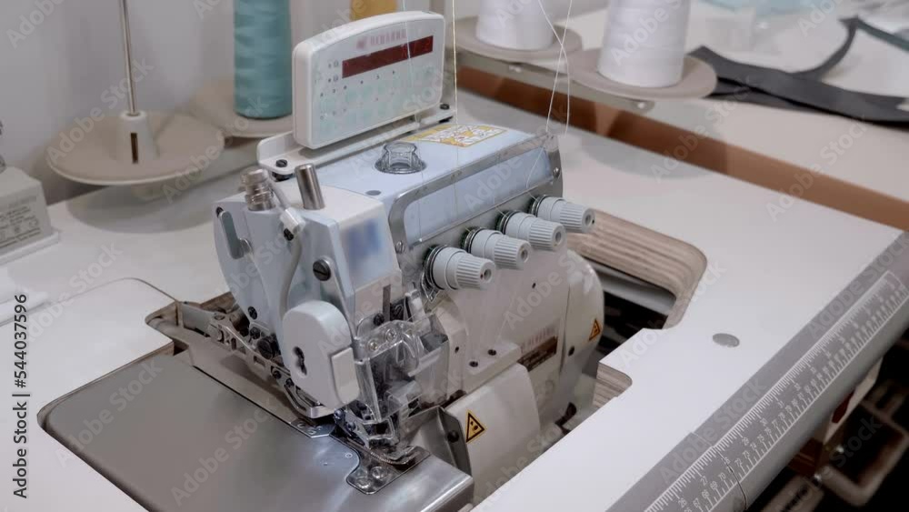 Industrial, professional, personal, sewing machine with many additional highly specialized functions and display for process control. Shot in motion. Macro. Closeup Industrial, professional, personal, sewing machine with many additional highly specialized functions and display for process control. Shot in motion. Macro. Closeup