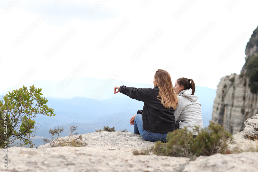 Two trekkers contemplating nature in a cliff Two trekkers contemplating nature in a cliff