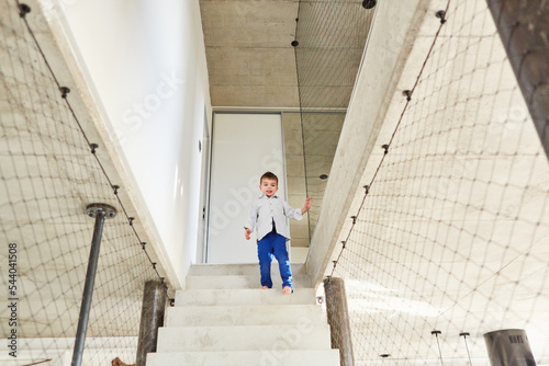 Junge beim Treppensteigen auf einer steilen Treppe © Robert Kneschke