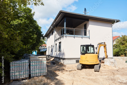 Fresh facade of house during house construction with excavator © Robert Kneschke