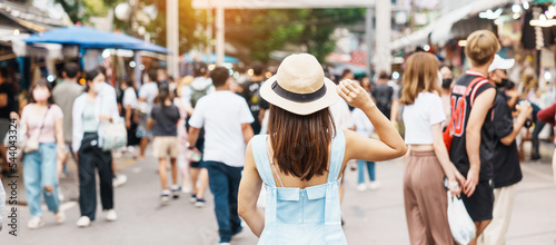 woman traveling with hat, Asian traveler standing at Chatuchak Weekend Market, landmark and popular for tourist attractions in Bangkok, Thailand. Travel in Southeast Asia concept
