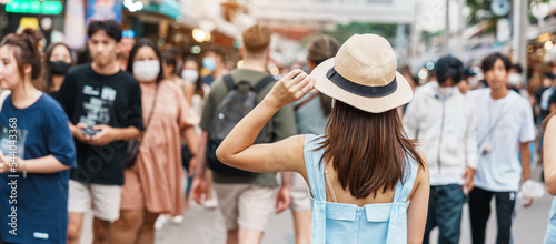 woman traveling with hat, Asian traveler standing at Chatuchak Weekend Market, landmark and popular for tourist attractions in Bangkok, Thailand. Travel in Southeast Asia concept photo